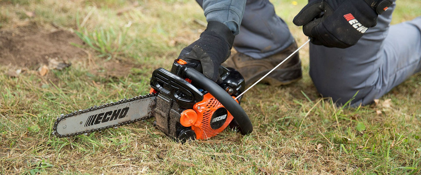 Person using a Echo CS-2511TES Top Handle chainsaw on grass, with Echo logo visible