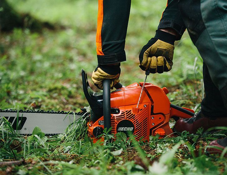 Echo CS-590 Chainsaw, image shows a person using a chainsaw in a forest setting