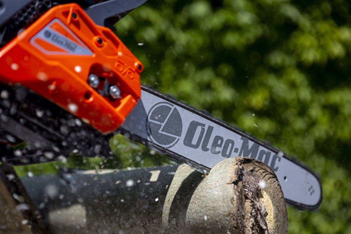Oleo-Mac Branded chainsaw in use on a background of trees