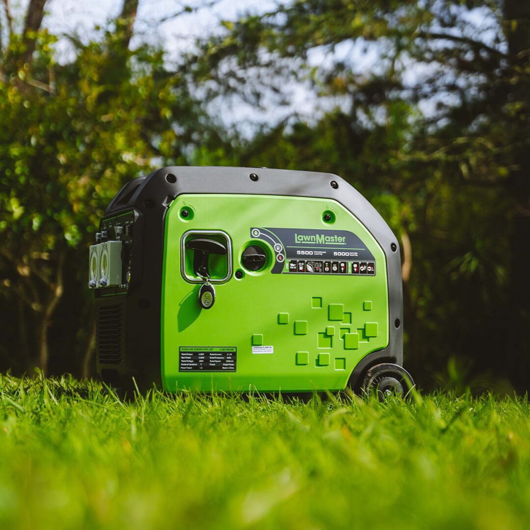 A green and black LawnMaster portable generator placed on a grassy lawn with trees in the background.