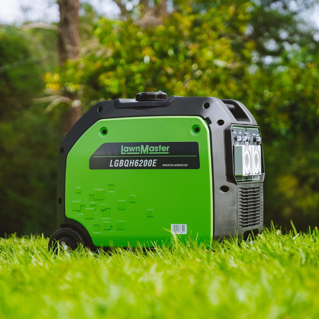 A LawnMaster generator sitting on green grass with a blurred garden background. The generator features a bright lime green body with black accents, a top handle, and a side control panel.