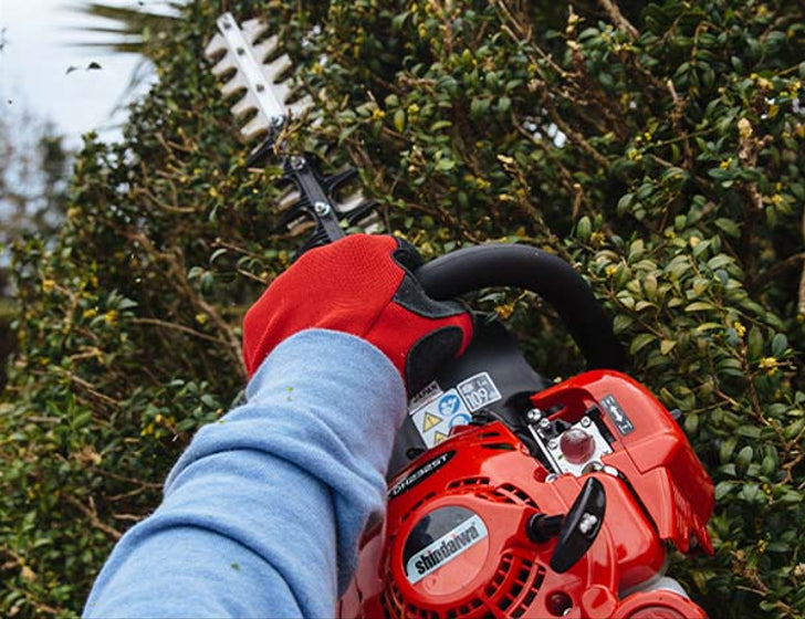 Red and blade Shindaiwa Hedgetrimmer in use
